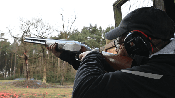A male client having a go at clay pigeon shooting on a corporate day in Manchester   